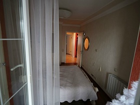 вид на светлую спальню из открытой балконной двери в семейной трешке