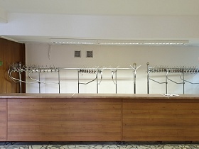 ряды напольных вешалок за деревянной стойкой раздевалки в светлом просторном холле столовой СССР