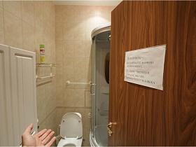 белый душевой комплекс, санузел, навесная стеклянная полка в ванной комнате через открытую дверь в съемной трехкомнатной квартире с ресепшн