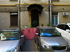 припаркованные машины у розовых ступеней к входной двери с навесом в подъезд дома на Долгоруковской