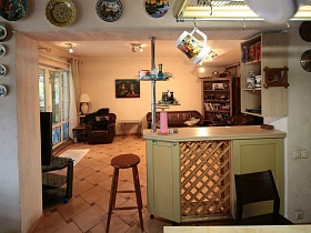 декоративные тарелки вокруг дверного проема с барной стойкой в зонированной комнате классической семейной дачи