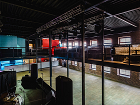 общий вид ночного двухуровнего клуба лофт с музыкальной аппаратурой и просторной танцевальной площадкой на первом этаже и зоной отдыха на втором
