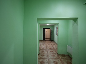 коричневая с рисунком квадратная плитка на полу просторного холла с салатовыми стенами и входными дверьми в жилые квартиры многоэтажки в Котельниках