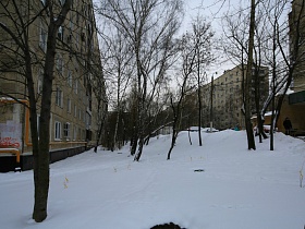 сугробы снега на придомовой территории многоэтажных домов