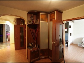 угловой коричневый шкаф в просторной прихожей современной трехкомнатной квартиры нетипичной планировки
