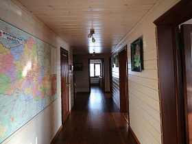 карта Московской области на стене длинного коридора с открытыми дверьми в разные комнаты просторного деревянного дома