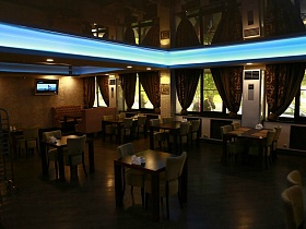 общий вид уютного зала с неоновой подсветкой подвесного потолка над индивидуальными столиками хорошего ресторана автобазы на Юге Москвы