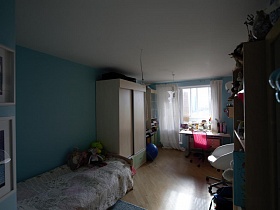 детская кровать, шкаф для одежды, шкафы с открытыми полками, письменный стол у окна голубой спальной комнаты стильной трешке минимализм в Икеа стиле