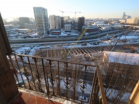 вид с открытого балкона жилой трехкомнатной квартиры на масштабное строительство микрорайона