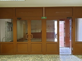 зеленая табличка над двойными входными коричневыми дверьми со стеклянными вставками в светлом холле столовой СССР