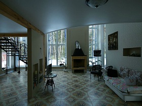 просторный зонированный холл с лестницей на второй этаж и зоной отдыха с камином, диваном и телевизором в элитном недостроенном доме