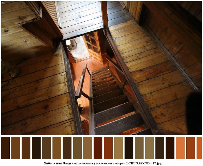 открытая дверь в деревянном полу мансарды на лестницу с перилами в небольшом домике отшельника среди новостроек