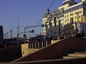 двусторонняя бетонная лестница с многочисленными ступенями и ограждением Москворецкого моста в оживленной части города