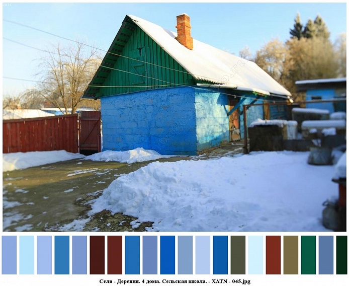 кирпичная труба на заснеженной крыше блочного голубого дома на участке с расчищенными дорожками от снега, за деревянным коричневым забором