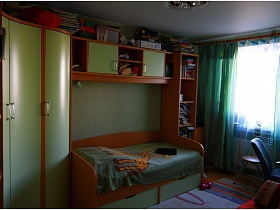 покрывало с жирафом на деревянной кровати детской мебели с салатовыми дверцами в детской комнате приличной трешки панельного дома