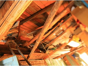 многочисленные деревянные балки, стойки, лестница внутри дома в деревне