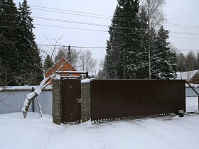 коричневые входные ворота и ворота для машины во двор кирпичного двухэтажного дома