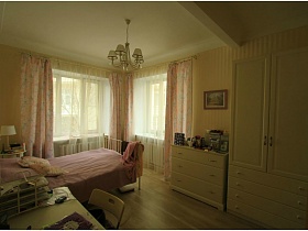 просторная светлая спальная комната с мебелью молочного цвета с французским мотивом современной двухкомнатной квартиры