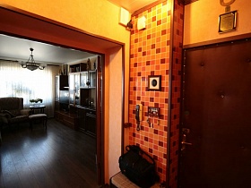мозаичная бежево-коричневая отделочная стена у входной двери квартиры оператора