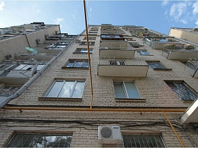 вид снизу на  белое кирпичное многоэтажное жилое здание на Садовом