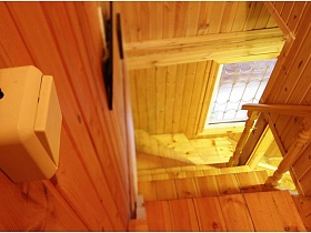окно на лестничной площадке деревянной лестницы на даче