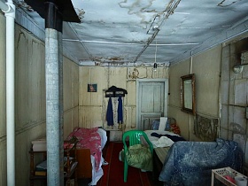 две кровати у стены с зеркалом на стене и вешалкой для одежды в спальной комнате обычной Советской даче