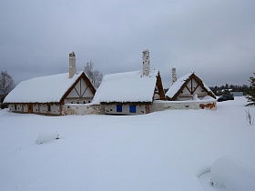 шапки снега на крышах домиков-мазанка и вокруг территории ресторана , стилизованного под хутор в коттеджном поселке