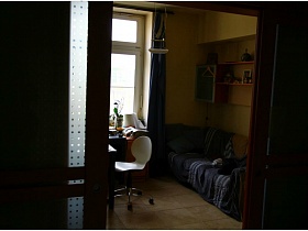 темно-серое покрывало с белыми полосками на бежевом мягком диване с подушками у окна с темными шторами в зонированной комнате через открытые раздвижные межкомнатные двери двухкомнатной квартиры с видом на Москва-сити