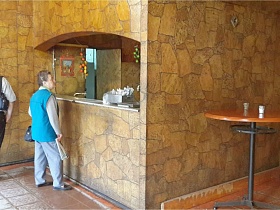 круглый деревянный барный столик на ножке у прилавка в зале класической рюмочной, бутербродной, закусочной СССР