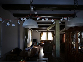коричневые деревянные балки на белом потолке зонированных комнат загородного деревянного дома для съемок кино