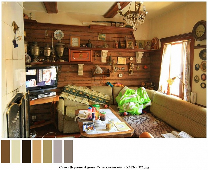 прямоугольный столик с продуктами у светлого мягкого углового дивана , разнообразные иконы на деревянной настенной полке над диваном,подвесная люстра на деревянной балке в потолке комнаты дома на селе
