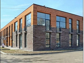 серое наполовину с коричневым кирпичное двух этажное здание с кафе лофт