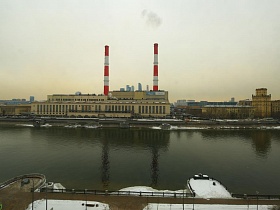 вид из окна современной девчачьей дизайнерской квартиры на Москву реку и промышленное предприятие на противоположном берегу