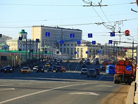 многочисленные синие дорожные знаки с указателями направлений движения транспорта на проводах над автомобильной размеченной дорогой на каменном мосту у Кремля