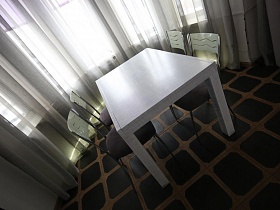 резные спинки стульев у белого добротного стола в гостиной дома