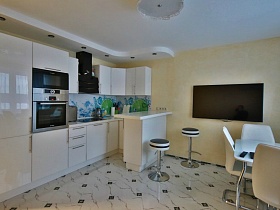 большой плоский телевизор на кремовой стене современной кухни в евро квартире Новостроя