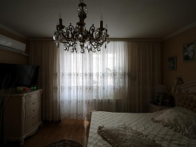 белая гардина на всю стену с окном в спальне большой квартиры врача