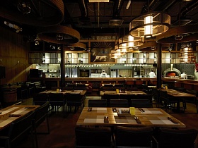сильно освещенная зона кухни с длинной барной стойкой просматривается с любого столика уютного крафтового ресторана