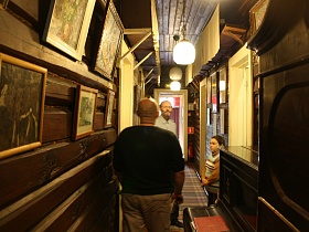 старинное пианино у окна узкого коридора с картинами на стене советской деревянной художественной дачи-музей