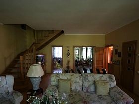 белый потолок и светлые стены уютной гостиной с мягкой мебелью на даче в соснах