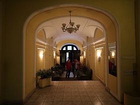 общий вид чистого, ухоженного парадного подъезда СССР 2 с арочнвм проемом на лестнице первого этажа, и входными дверьми