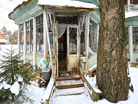 веник, совок и дорожка на крыльце у открытых входных дверей на веранду советской деревяной дачи художника с овальной террасой