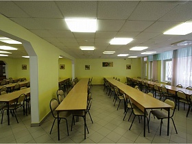 ровные ряды столов в раздельных зонах столовой школы