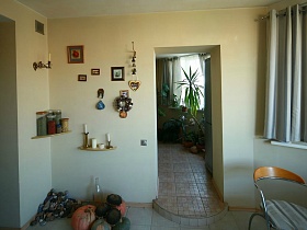 природные мелкие камни, тыква, шляпки подсолнухов у дверного проема с кухни на лоджию в современной трехкомнатной квартире геолога в многоэтажном жилом доме