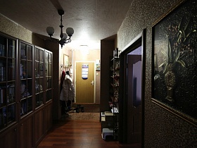 картина, шкаф и резной стелаж у стен красивой прихожей в обычной квартире стандартной многоэтажки