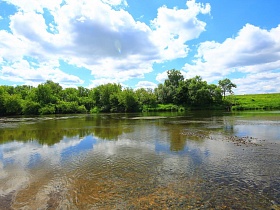насыщенные цвета лета отражаются в чистой воде извилистого устья реки в живописном месте-холмогоры