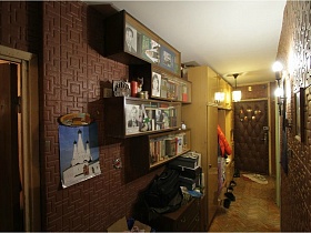 картины, светильник, деревянные полки с книгами под стеклом на стенах прихожей с коричневым пенопленом квартиры СССР 80-89гг стиля