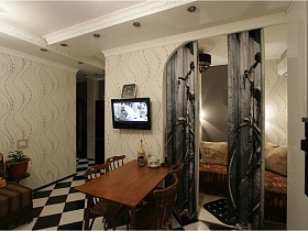 стулья со спинками вокруг прямоугольного обеденного стола у стены с арочным проемом в черно белой кухне с шахматным полом