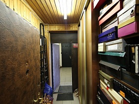 лестница-стремянка, шкаф-купе и стелажи с многочисленными коробками из под обуви в подсобке большой квартиры врача