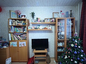 бежевый мебельный гарнитур с телевизором и новогодней елкой у окна